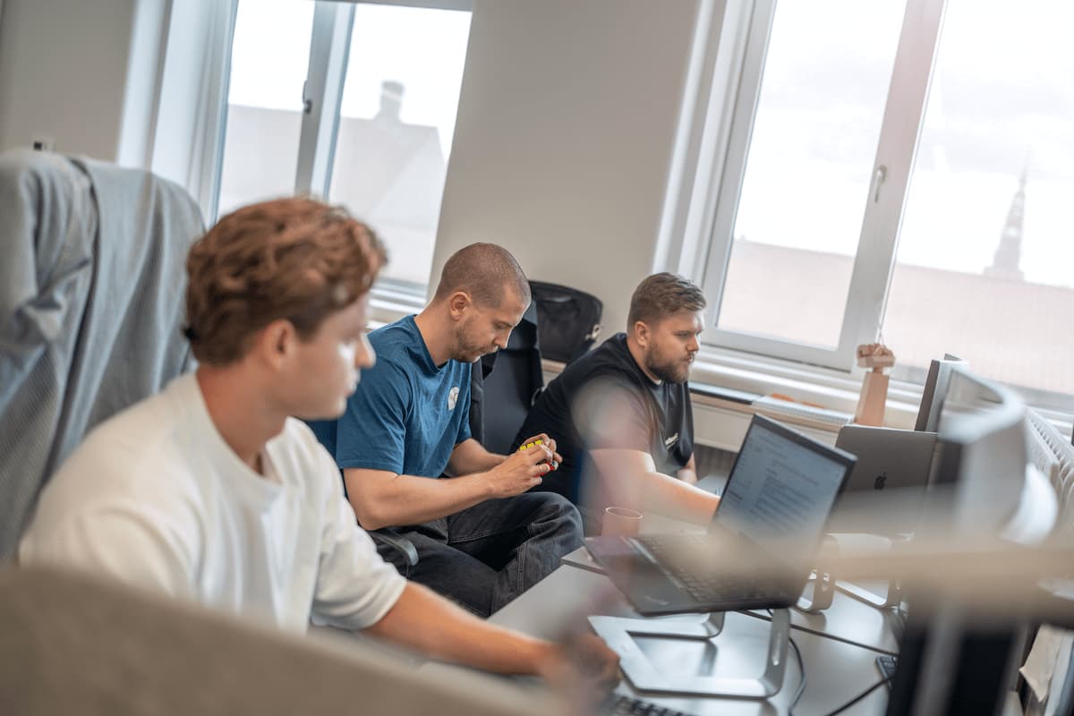 Tre Bording-medarbejdere arbejder sammen ved computere på kontoret