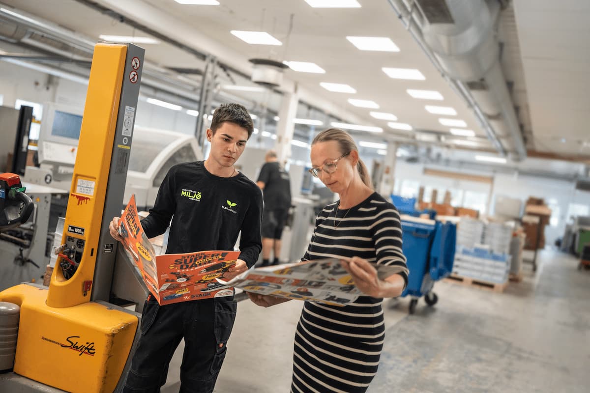 Medarbejdere kontrollerer trykte tilbudsaviser hos KLS PurePrint
