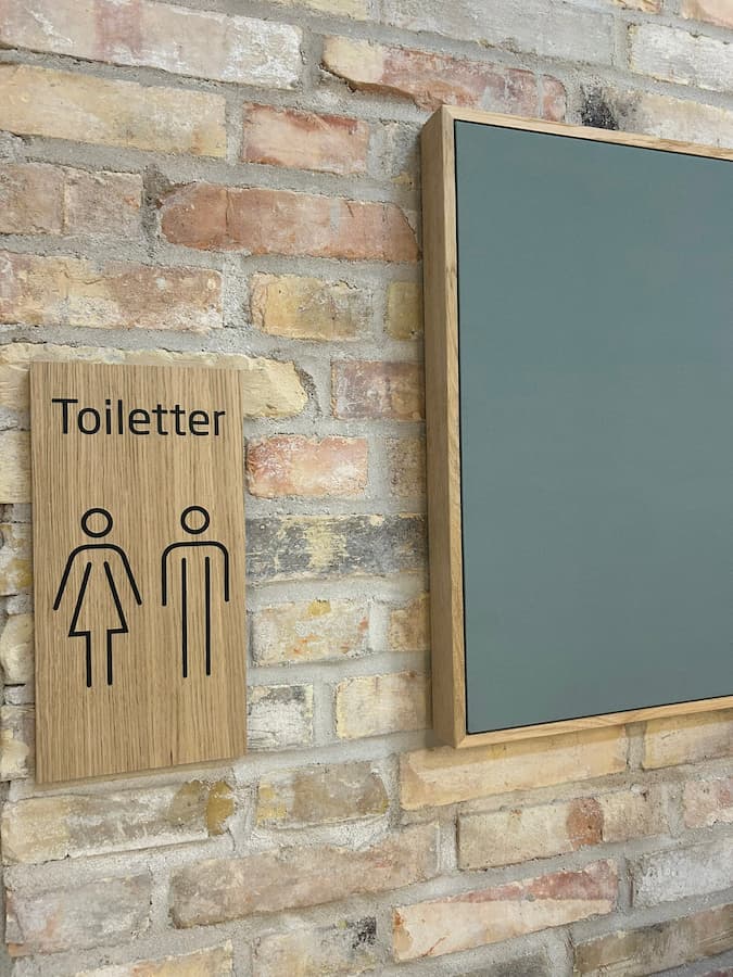 Toiletskilt i træ med piktogrammer for kvinder og mænd