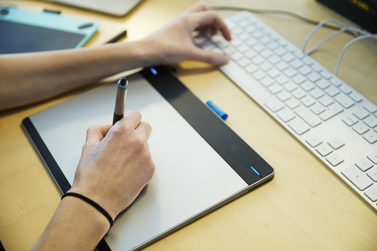 Grafisk designer arbejder med tegneplade og computer